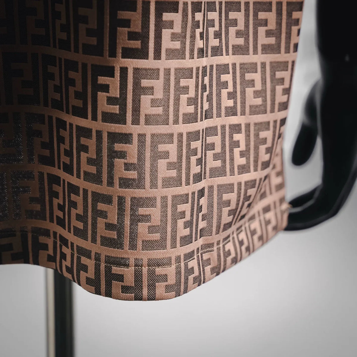 Close-up of Fendi FF monogram knit polo fabric in tan with dark pattern