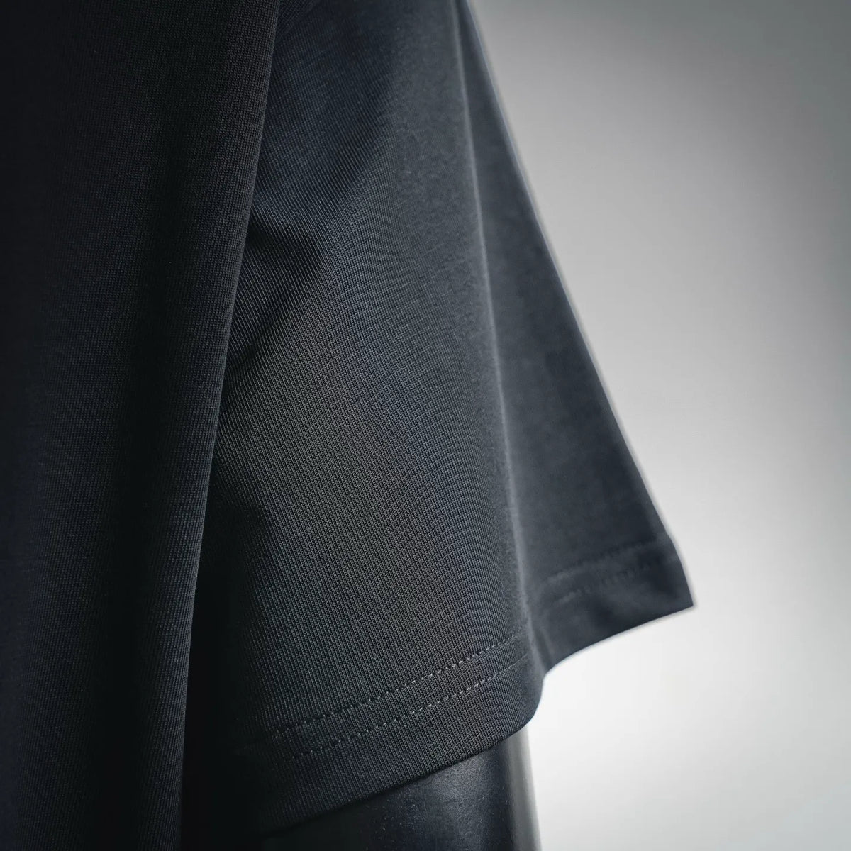 Black short-sleeve T-shirt cuff with visible contrast stitching