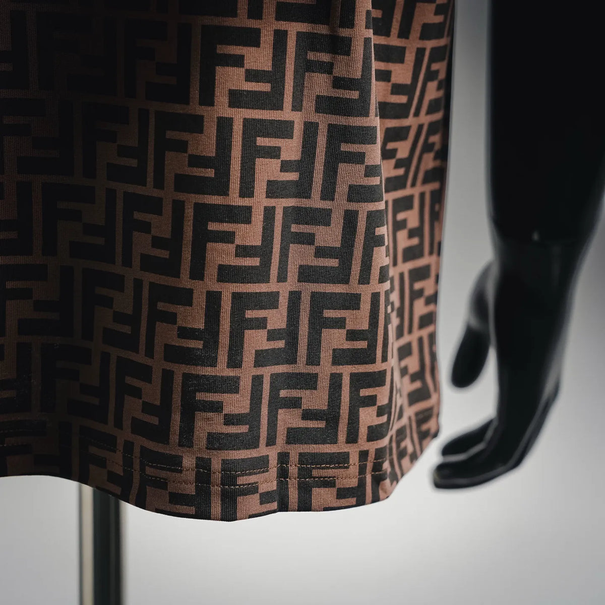 Close-up of brown fabric with repeating Fendi FF monogram pattern