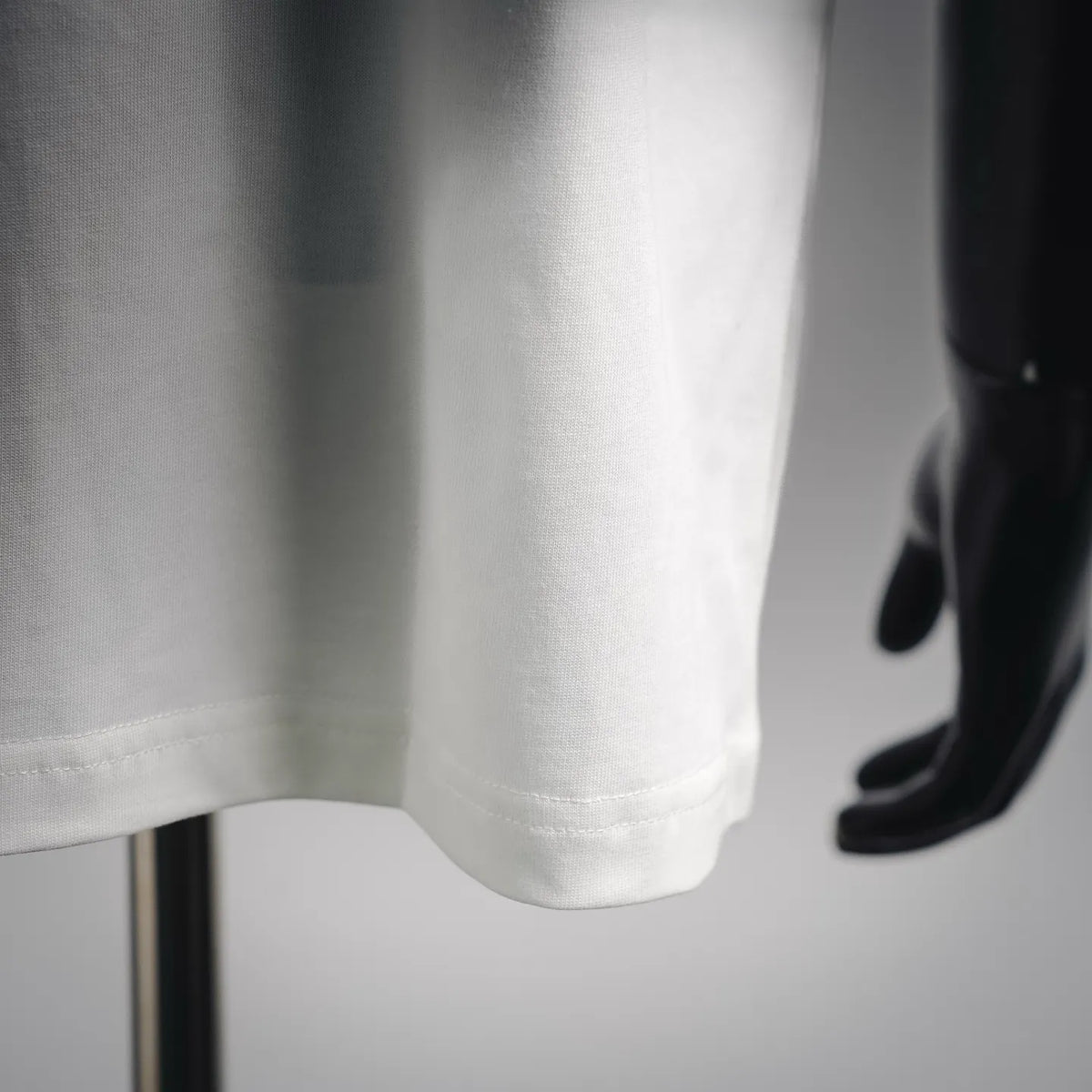 White T-shirt hem and side seam close-up with clean stitching