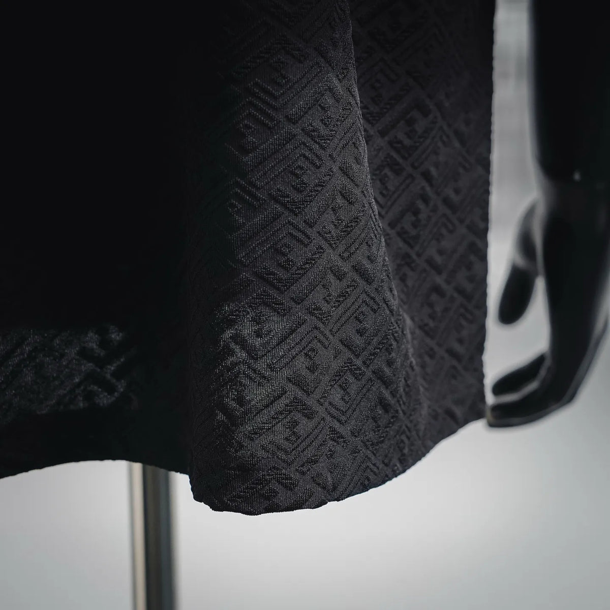 Dark short-sleeve shirt hem with textured allover logo pattern