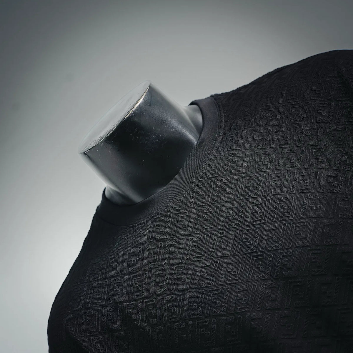 Dark short-sleeve shirt neckline with textured allover logo pattern