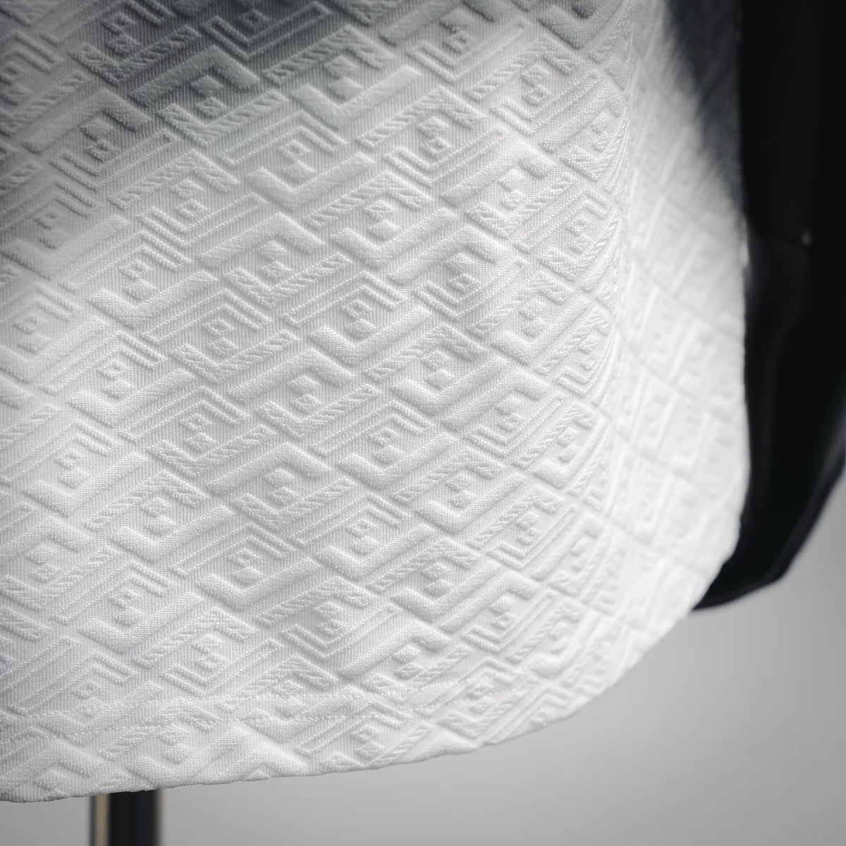 FENDI white T-shirt fabric close-up, embossed monogram pattern across chest