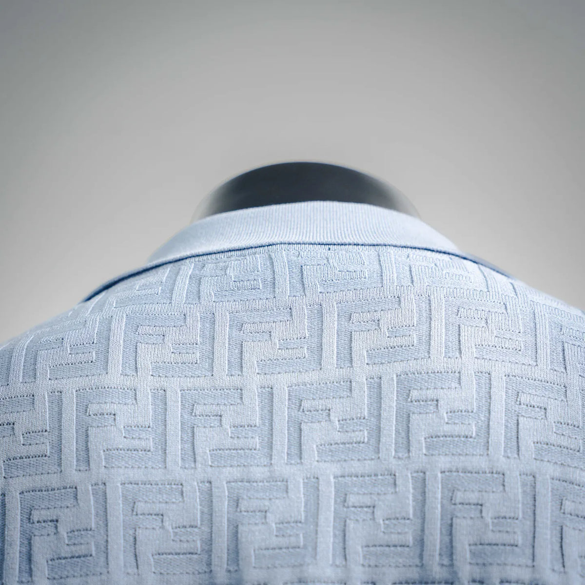 Light blue Fendi polo shirt collar and woven logo pattern close-up