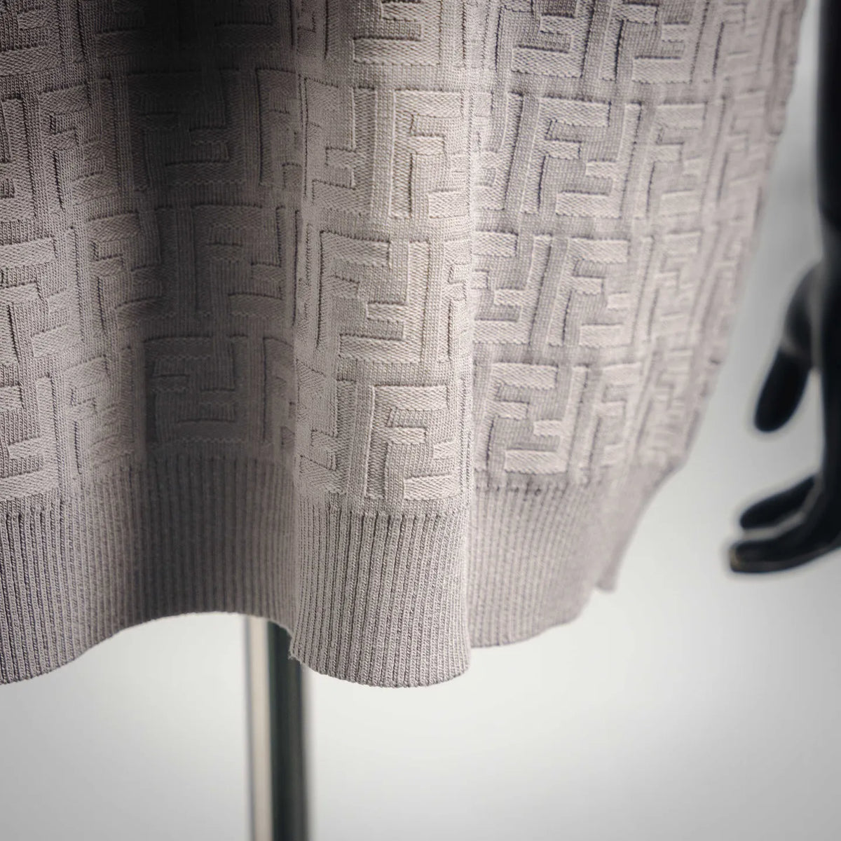 Light gray jacquard knit fabric with raised FF-style motif texture