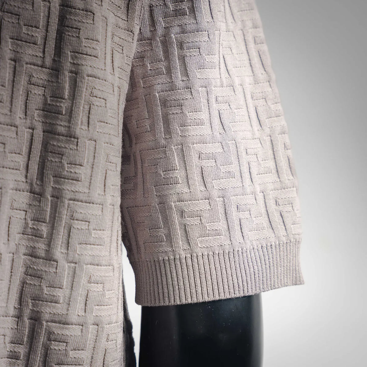 Light gray knit polo sleeve with ribbed cuff and FF-style jacquard texture