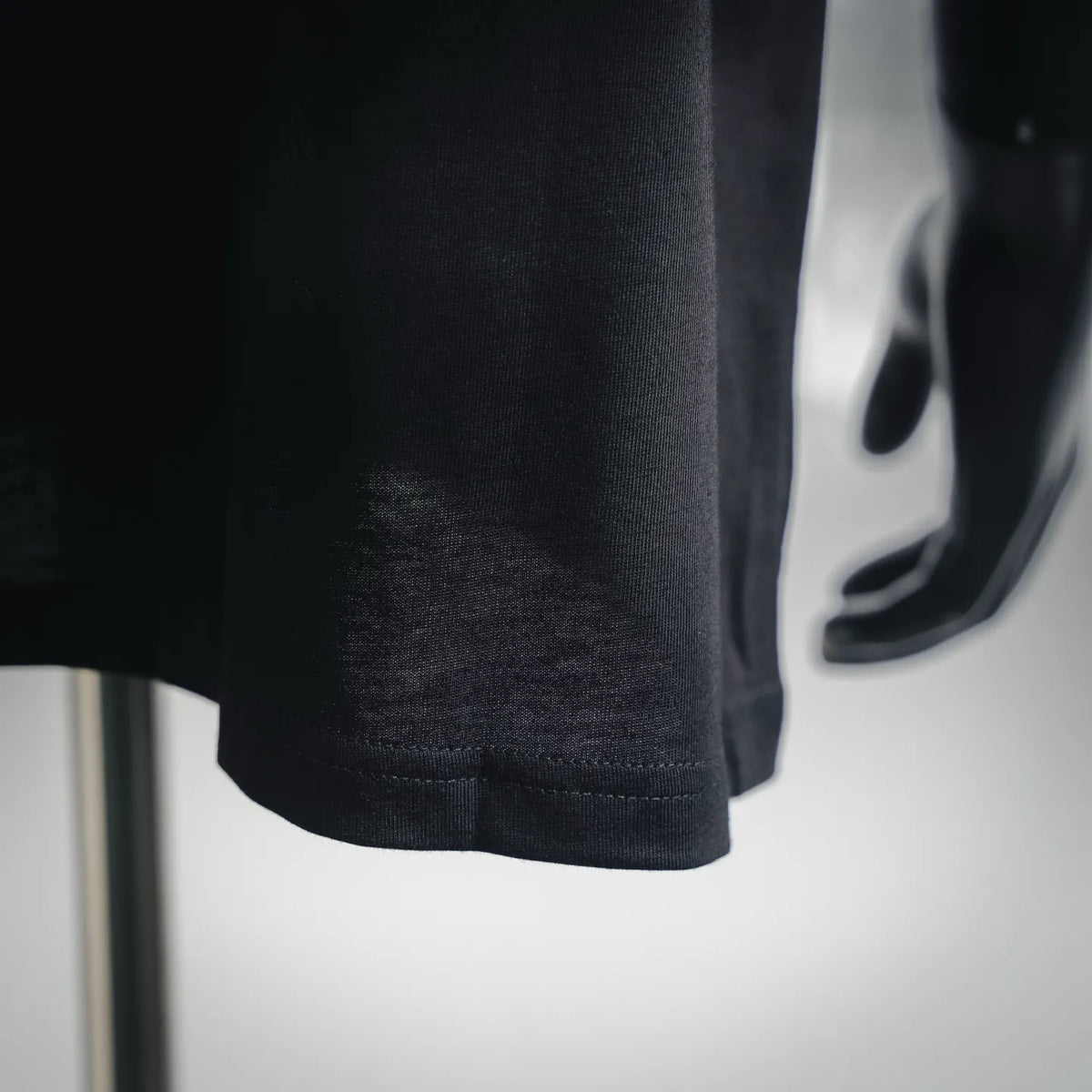 Black T-shirt hem close-up with stitched bottom edge