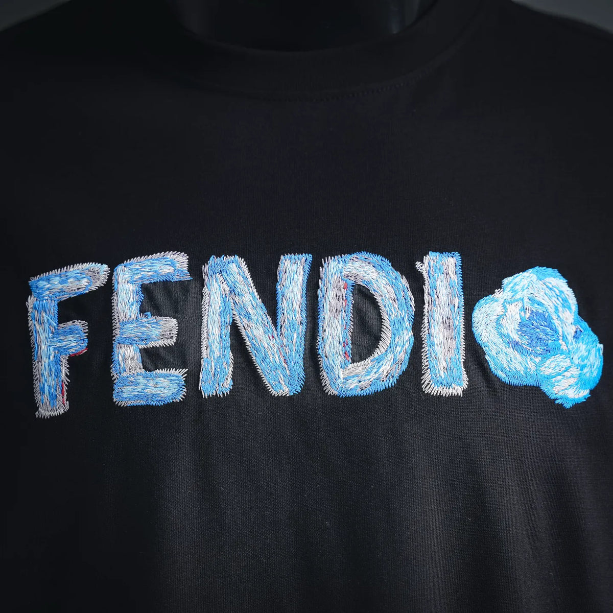 Black T-shirt front with large blue FENDI logo embroidery