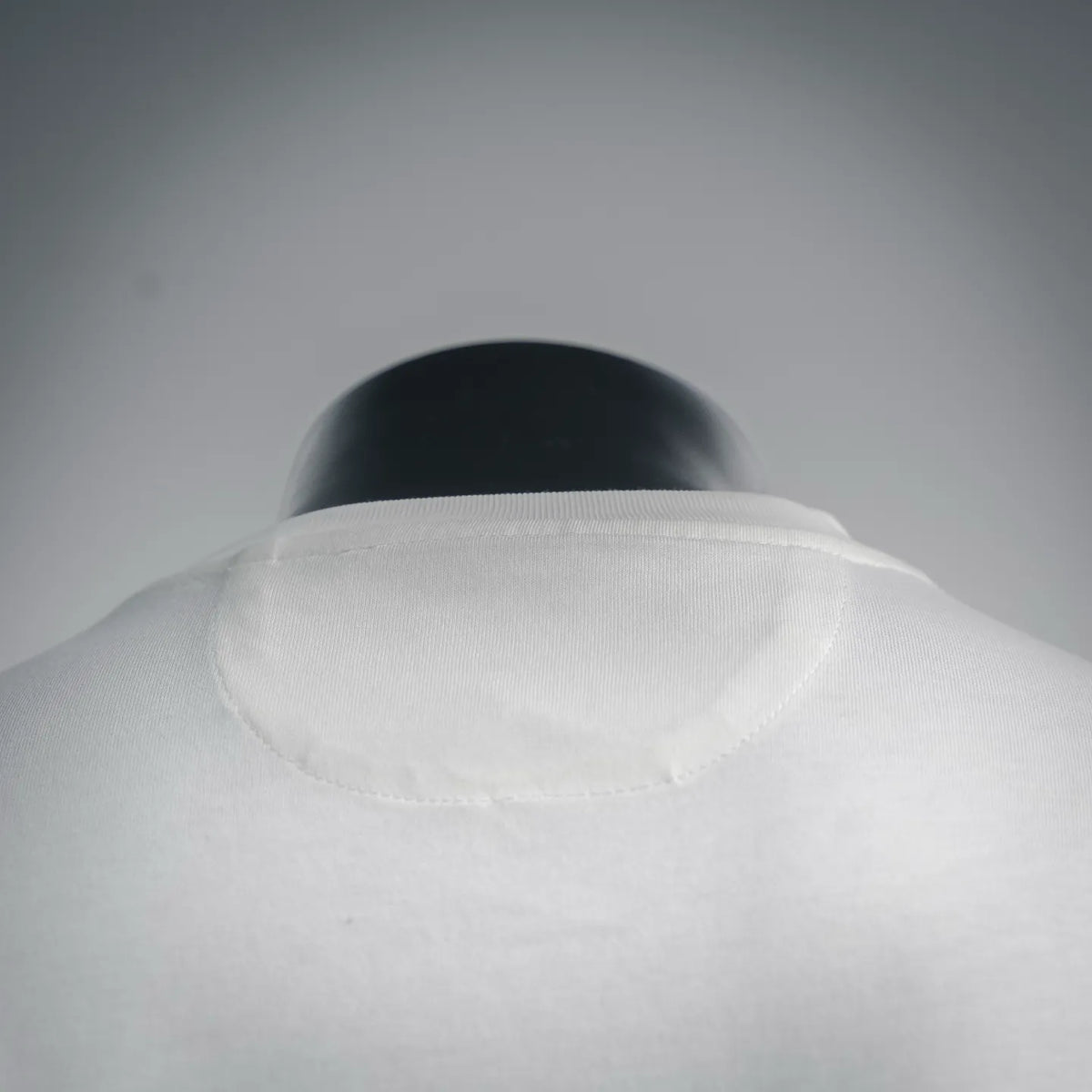 White crew-neck T-shirt collar with ribbed neckline on a mannequin.