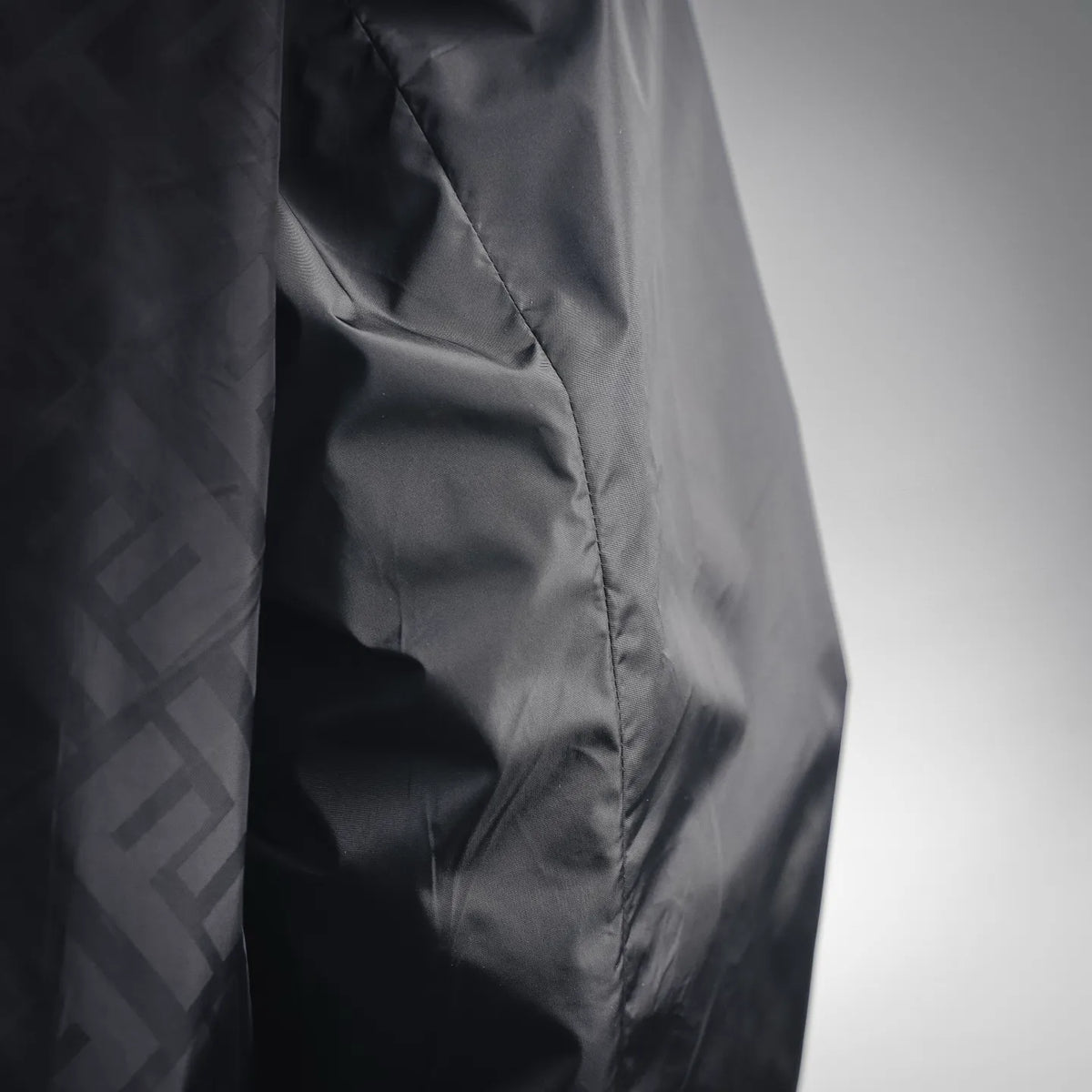 Black coat side panel with stitched seam and textured FF pattern