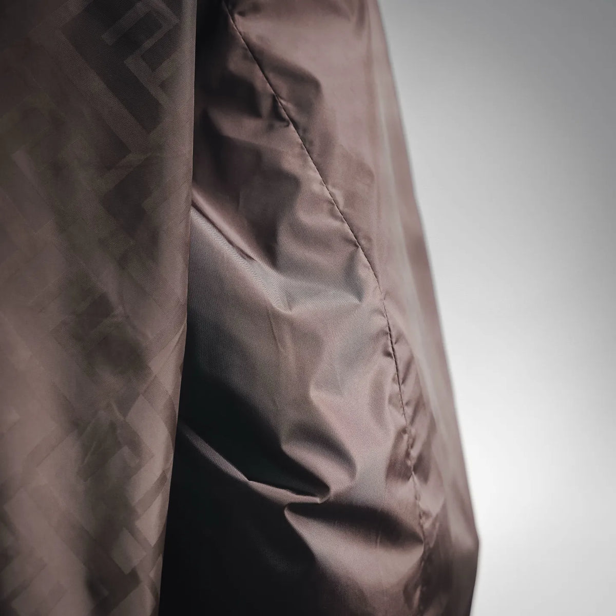 Coat side panel with stitched seams and FF logo patterned fabric
