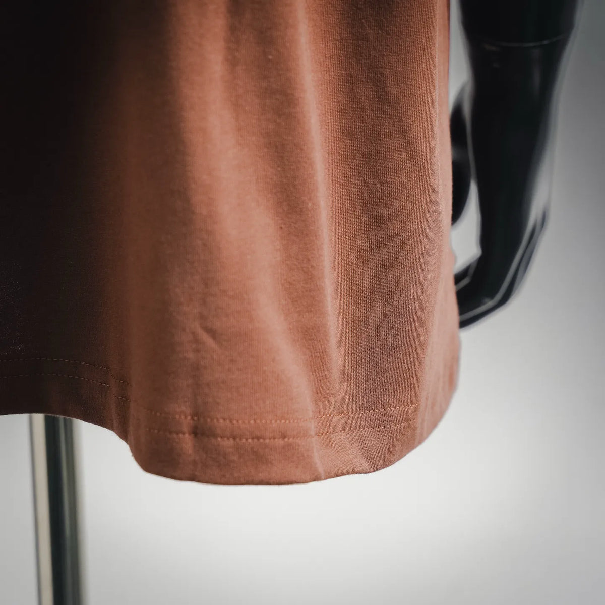Rust brown T-shirt hem with straight cut and visible stitching