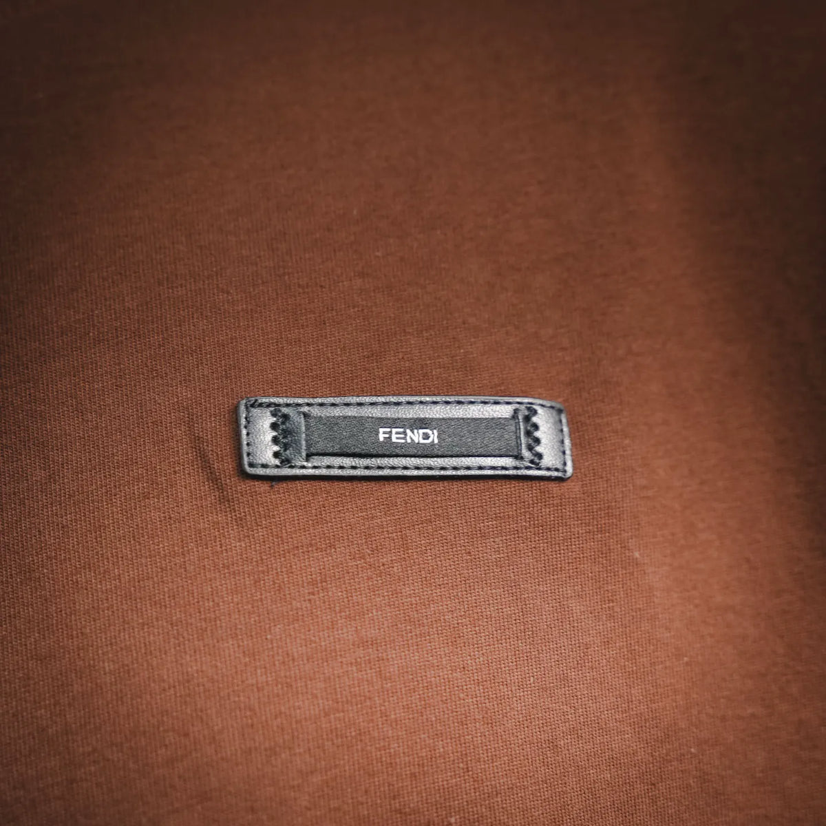 Fendi logo patch label on rust brown T-shirt chest