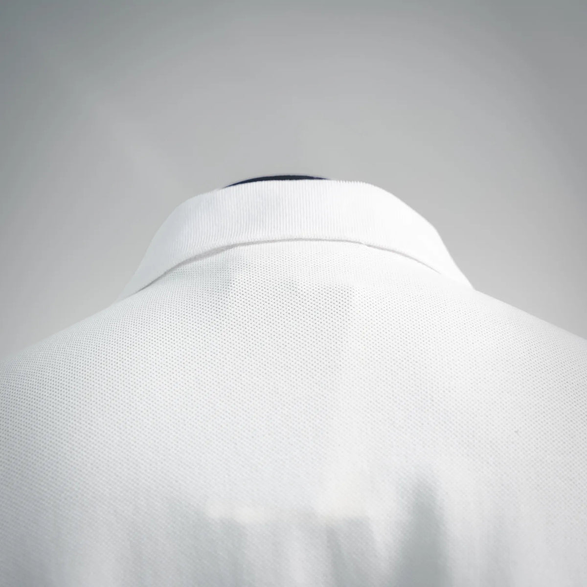 White polo shirt back collar close-up with smooth folded neckline.