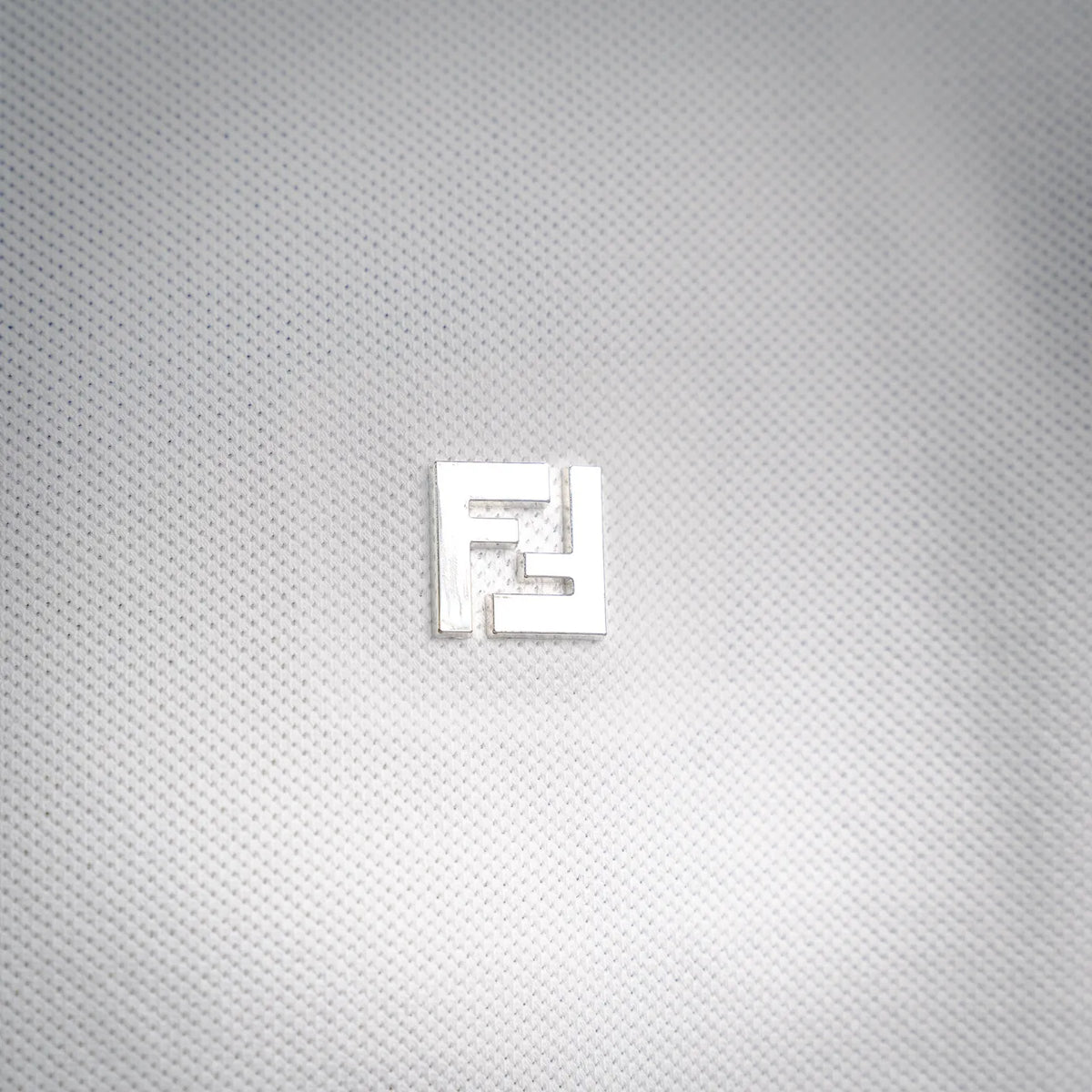 White Fendi polo shirt shoulder and collar close-up with button placket.