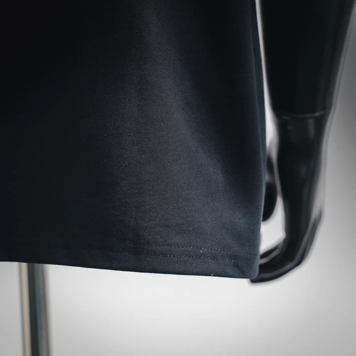 Black T-shirt hem and sleeve cuff detail on mannequin