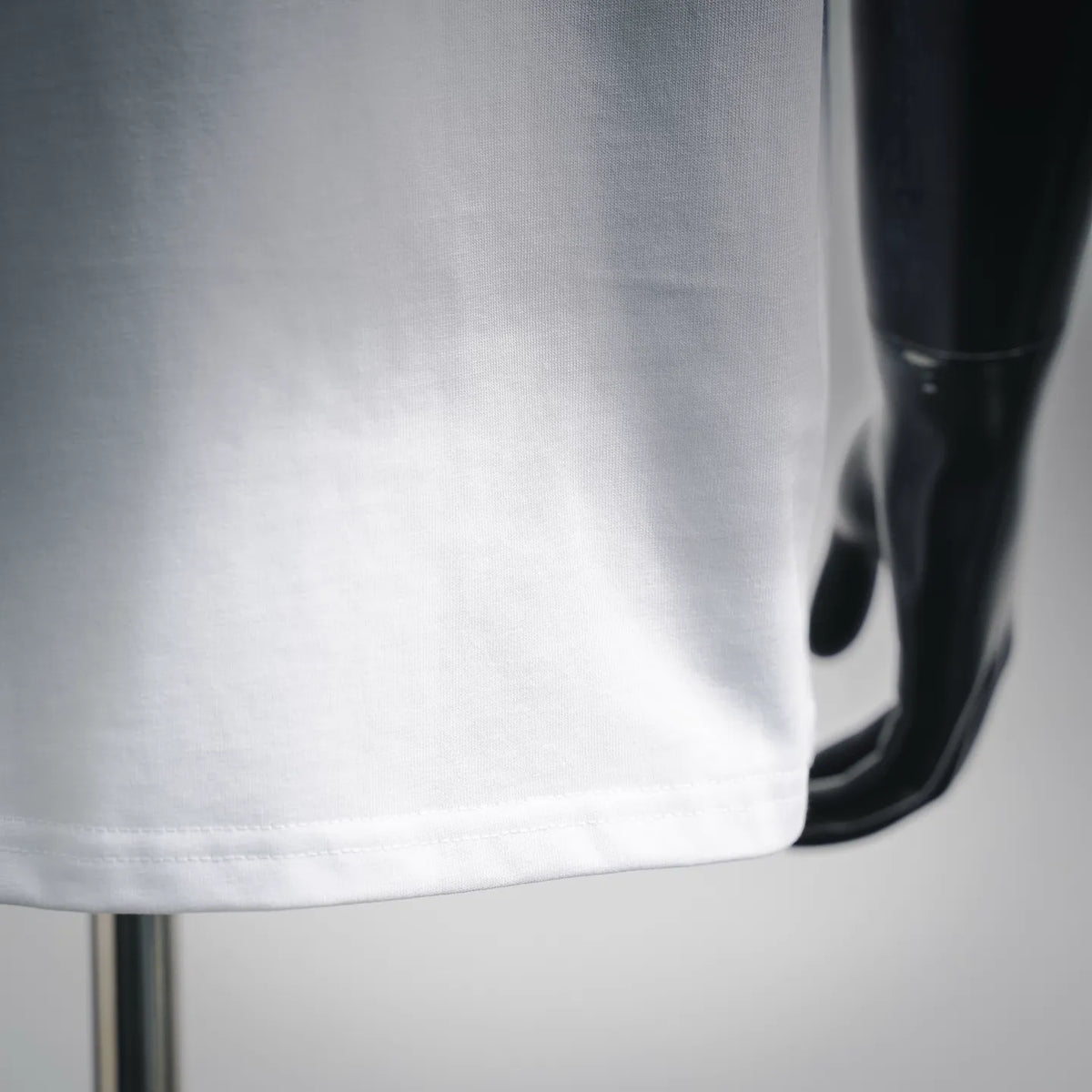 White short-sleeve T-shirt, close-up of hem and stitching detail
