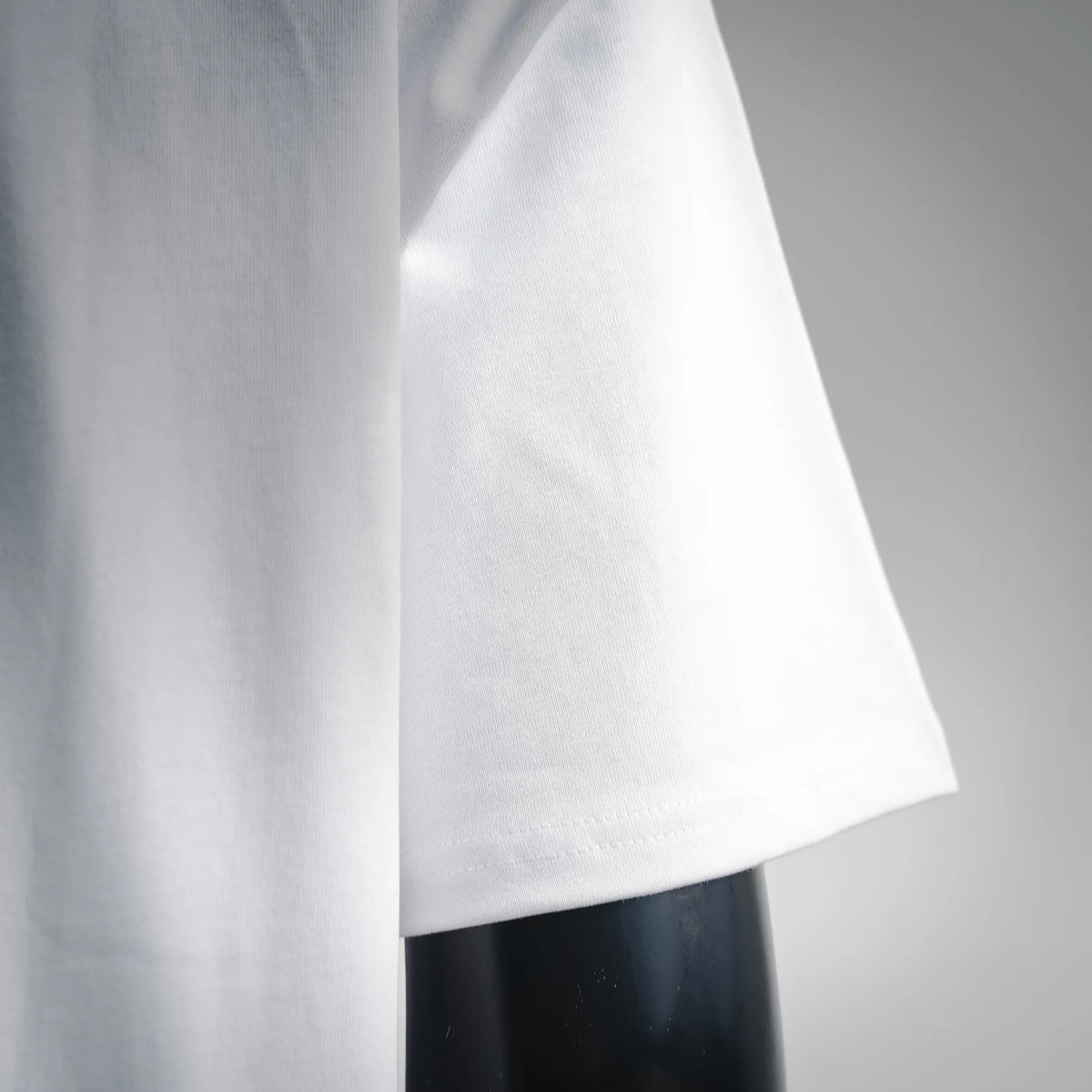 White short-sleeve T-shirt, close-up of sleeve hem and side seam