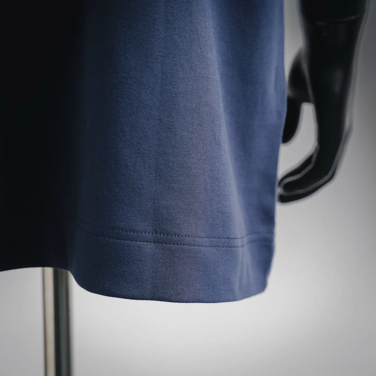 Dark blue short-sleeve T-shirt hem with stitched band and curved edge