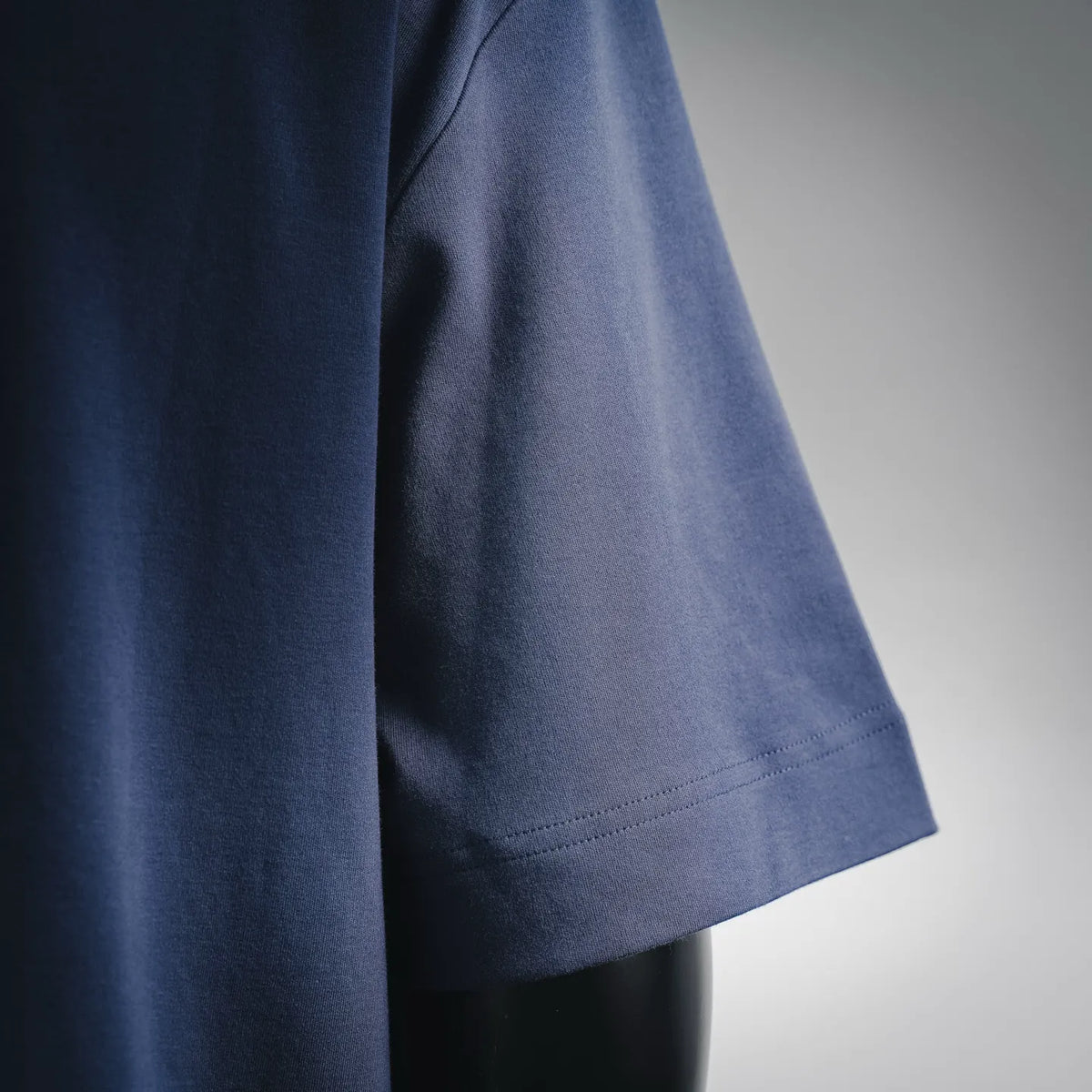Dark blue T-shirt side panel with seam and curved hem stitching