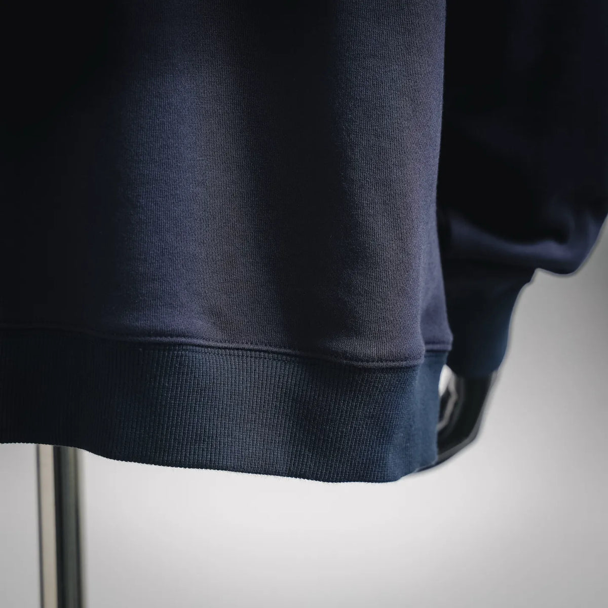 Navy hoodie sleeve cuff with ribbed trim and smooth knit fabric texture