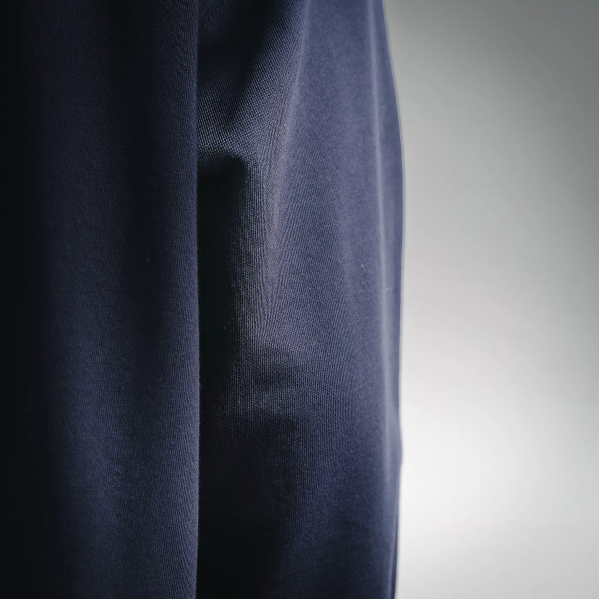 Navy hoodie fabric close-up showing vertical knit texture and drape