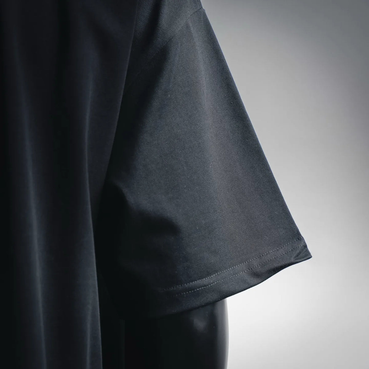 Men's short-sleeve T-shirt sleeve close-up, dark blue/black with stitched edge