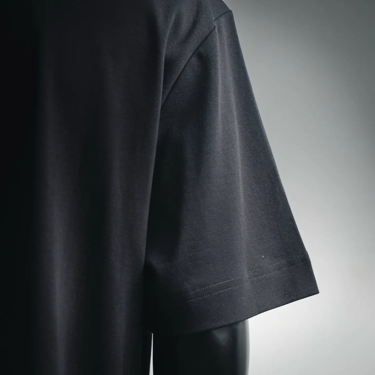 Black Fendi T-shirt sleeve and hem detail with visible stitching along the edge