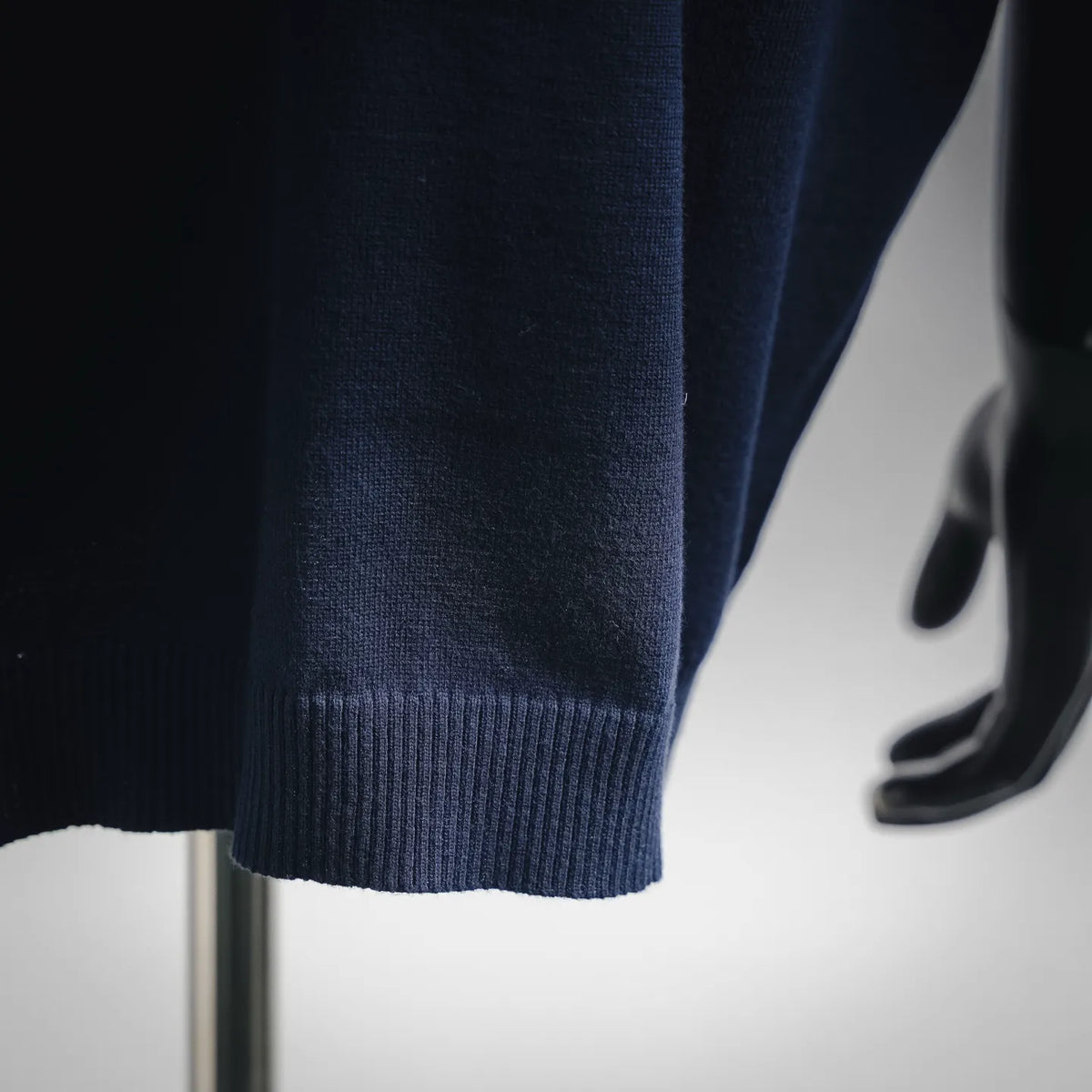 Navy knit sweater hem with ribbed lower cuff detail