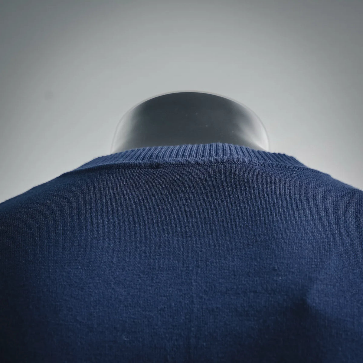 Navy knit sweater back with ribbed collar and shoulder seam detail