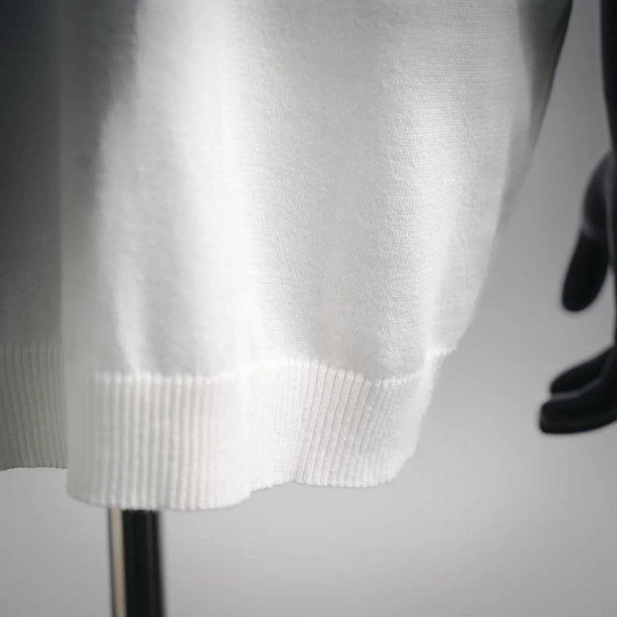 White ribbed knit hem with short sleeves, close-up