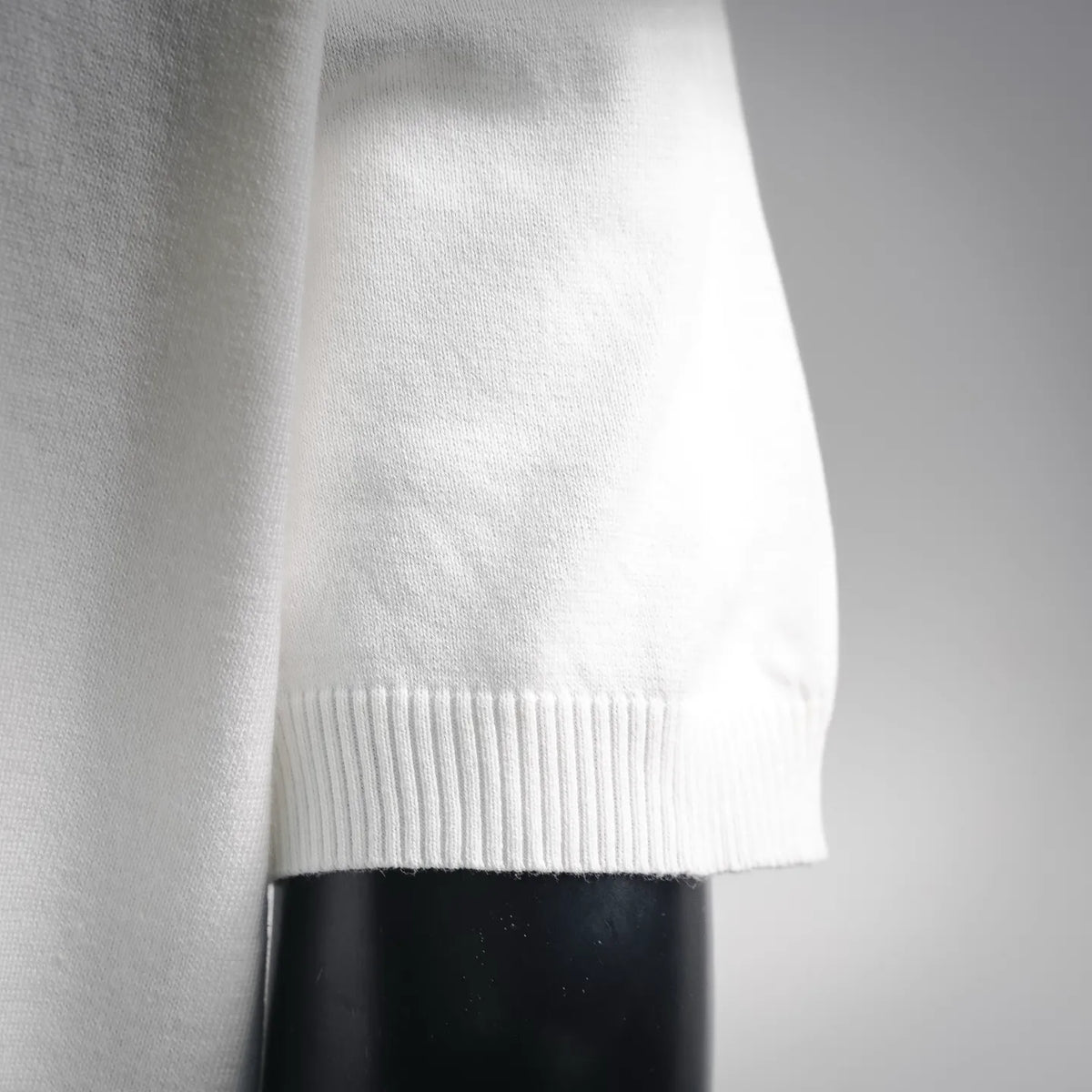 White short-sleeve knit top, ribbed sleeve hem close-up