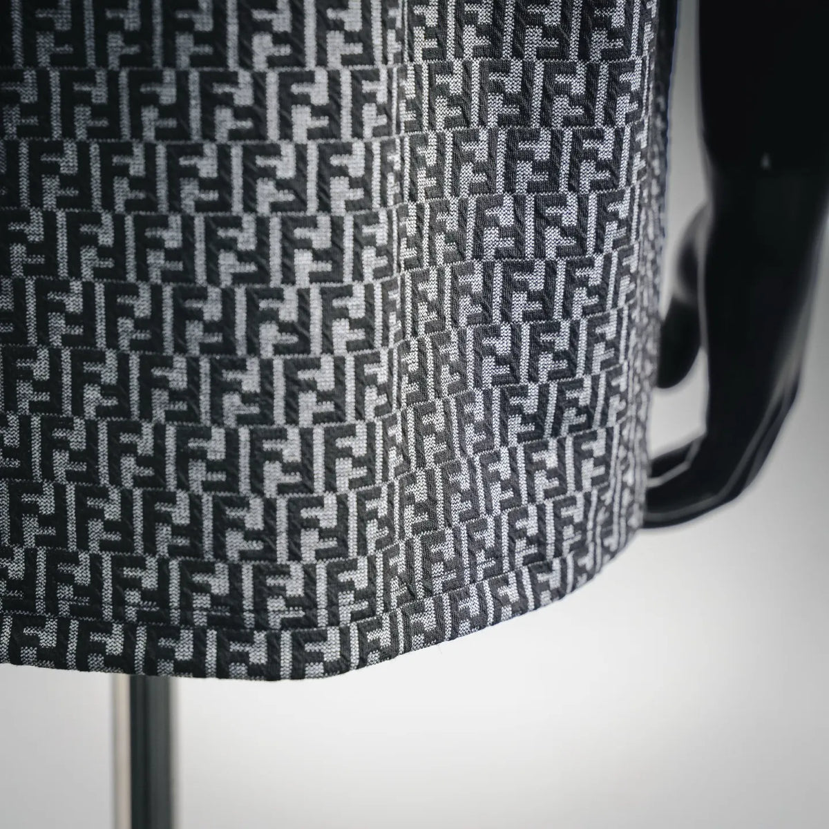 Close-up of FF monogram knit pattern on short-sleeve top in dark and light gray.