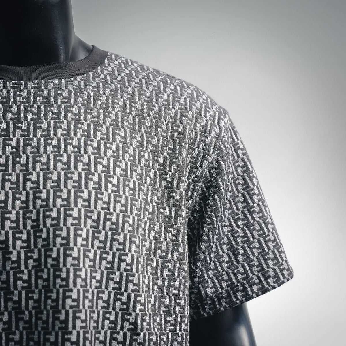 Side view of short-sleeve knit top with repeating FF pattern in dark and light gray.