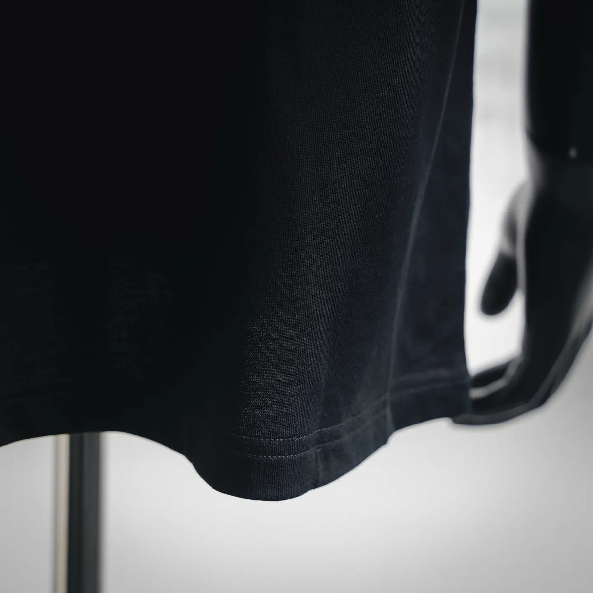 Dark short-sleeve T-shirt hem with stitched edge detail