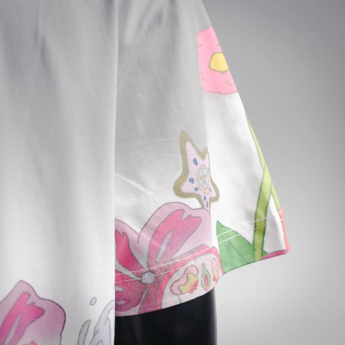 White T-shirt sleeve with colorful character and floral graphic