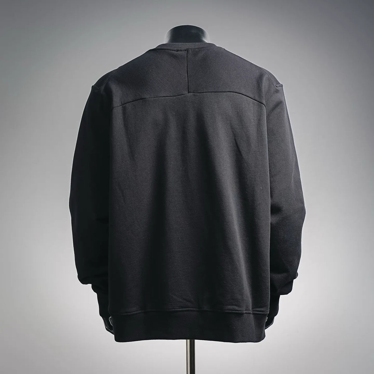 Black crewneck sweatshirt back view with ribbed hem and shoulder seam