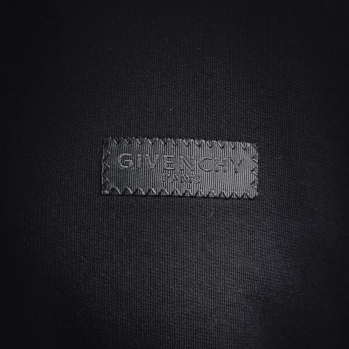 Black sweatshirt chest logo label stitched on fabric