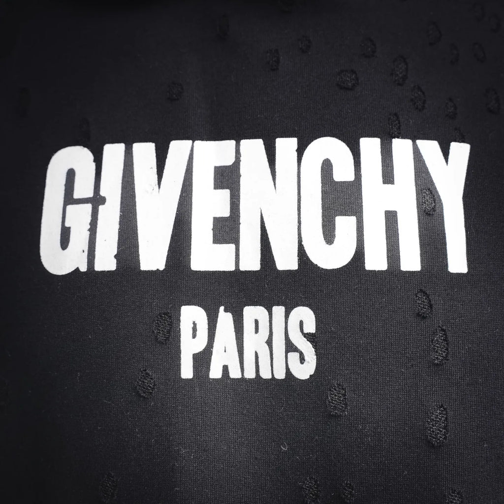 Close-up of white Givenchy Paris logo text on dark fabric