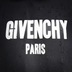 Close-up of white Givenchy Paris logo text on dark fabric