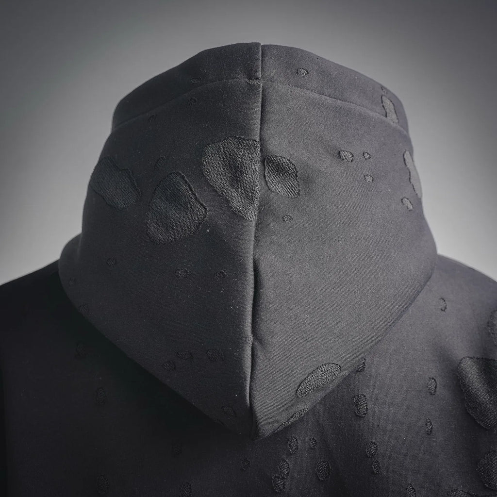 Hood close-up on black sweatshirt with textured pattern and soft hood shape