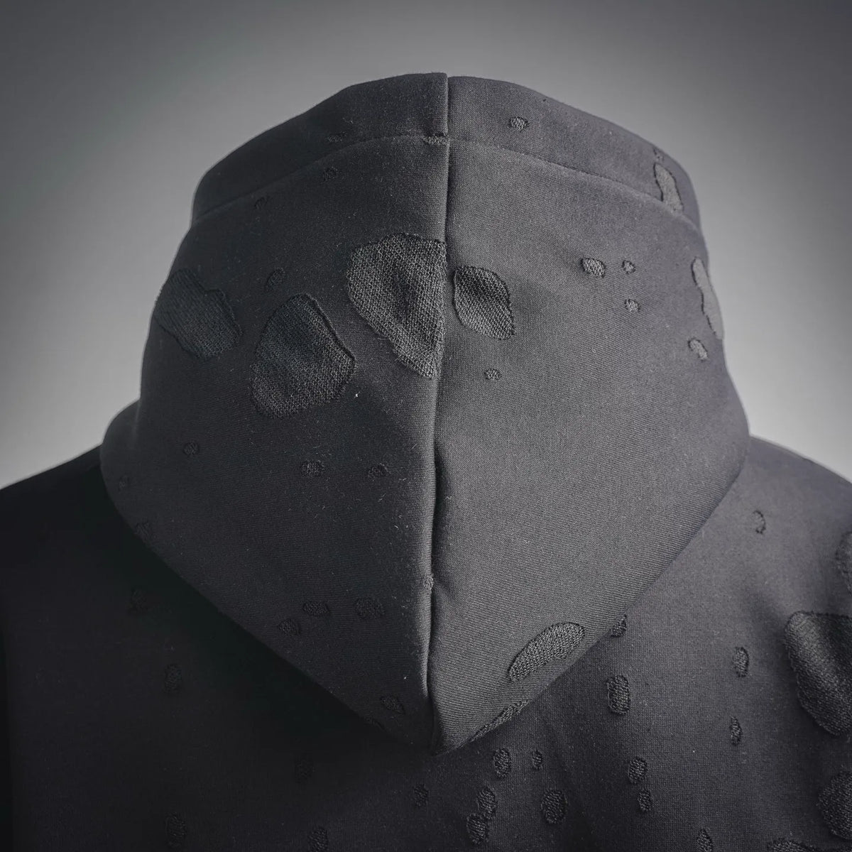 Hood close-up on black sweatshirt with textured pattern and soft hood shape