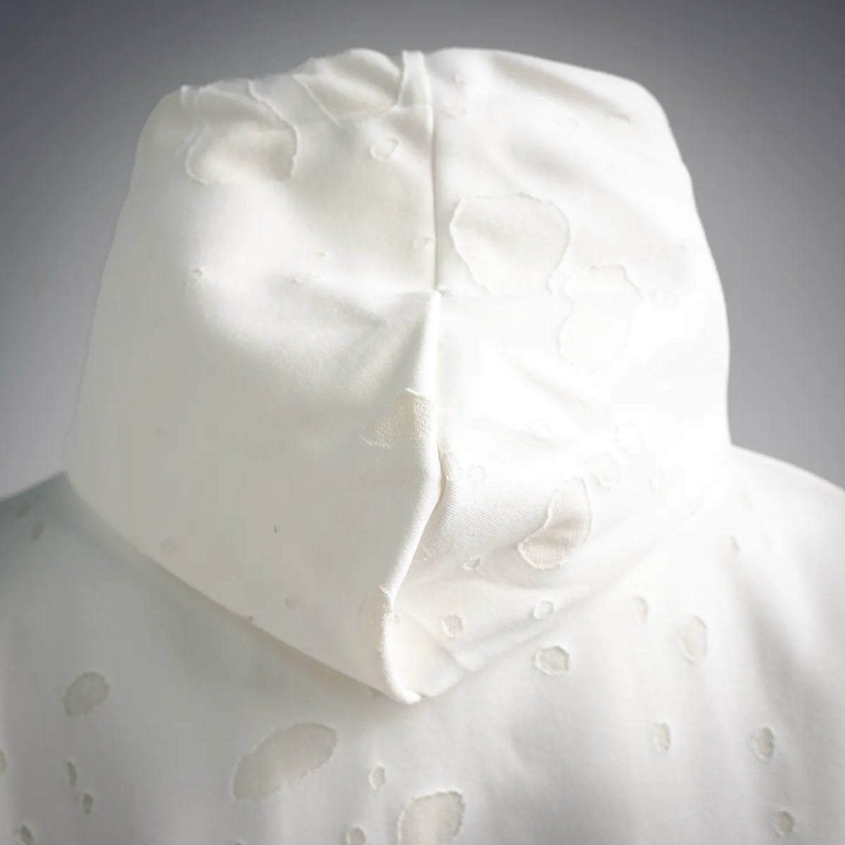White hooded sweatshirt hood close-up with textured dot pattern
