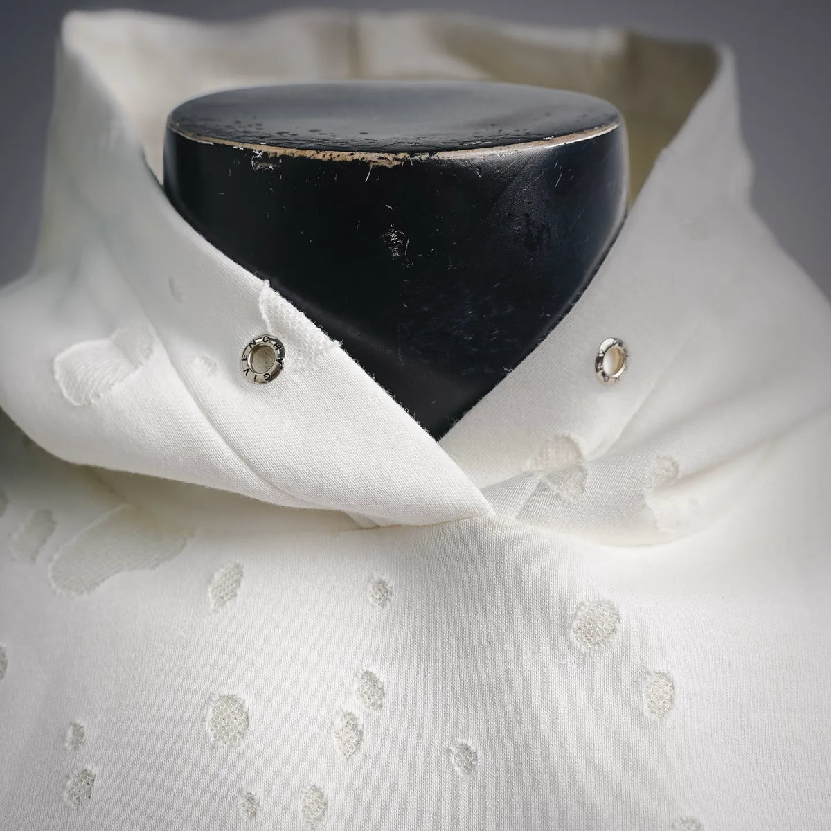 White hooded sweatshirt with dark inner hood and small silver button details