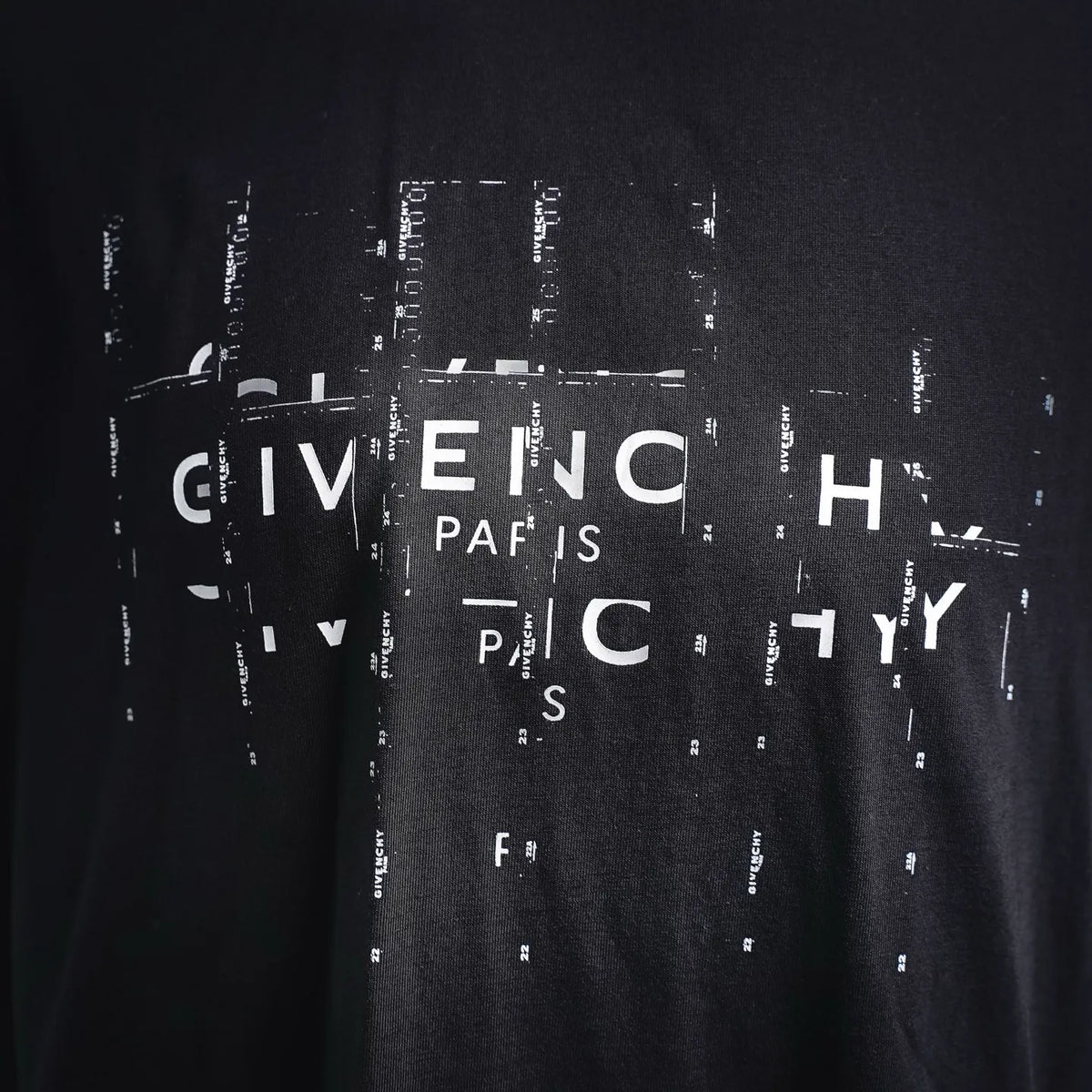 Dark T-shirt with large Givenchy lettering graphic print centered.