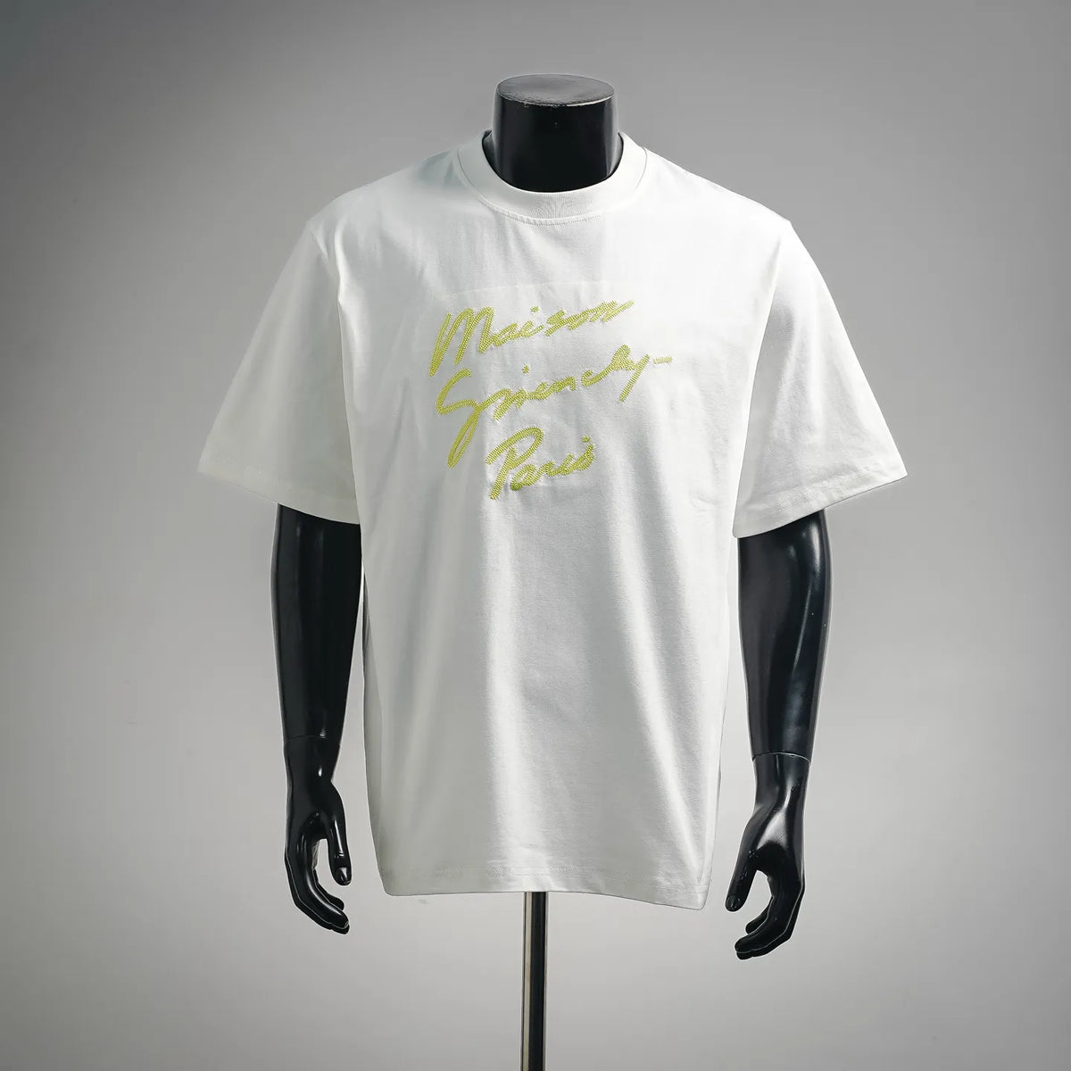 White short-sleeve T-shirt with yellow script graphic on the chest