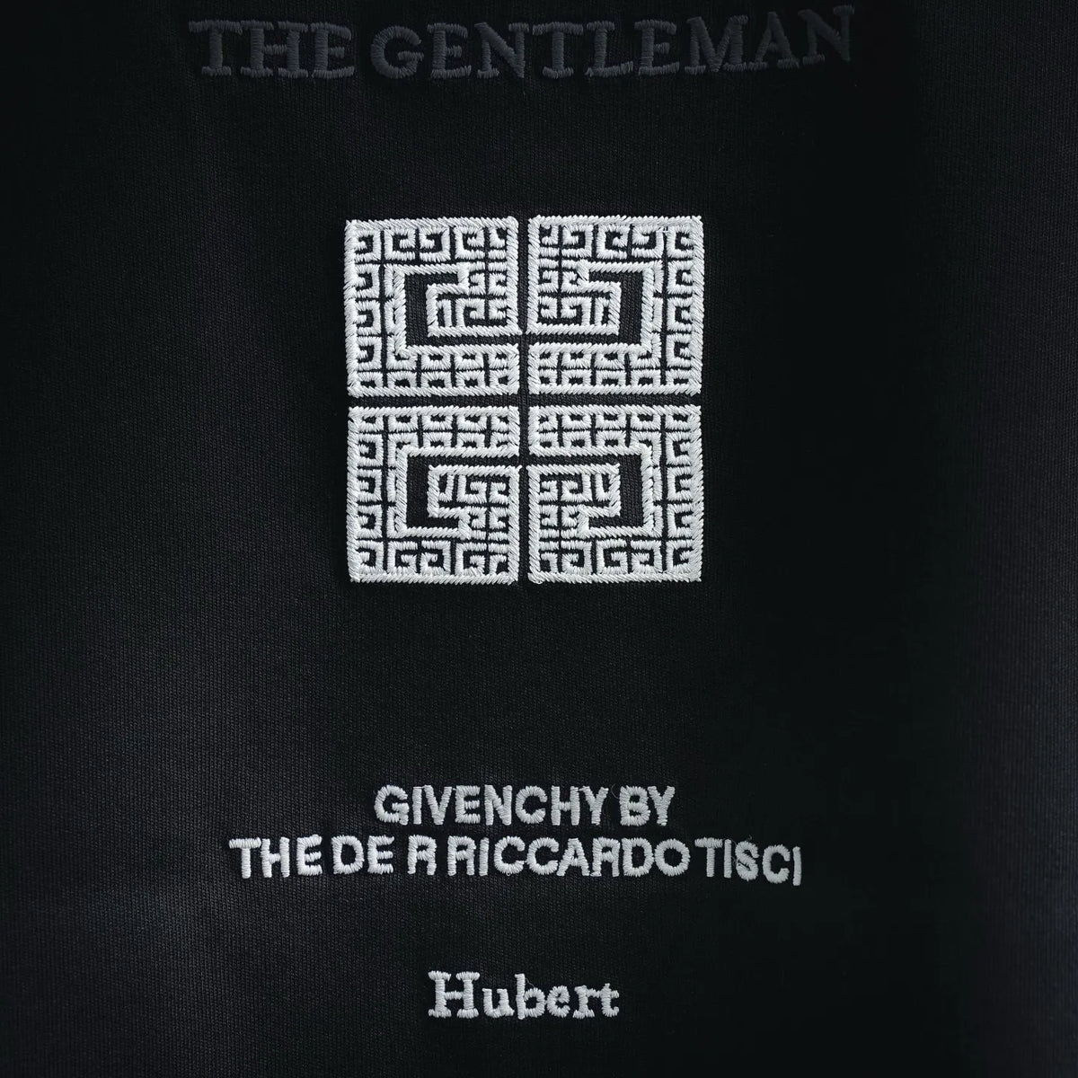 Black T-shirt close-up of back print with maze motif and text
