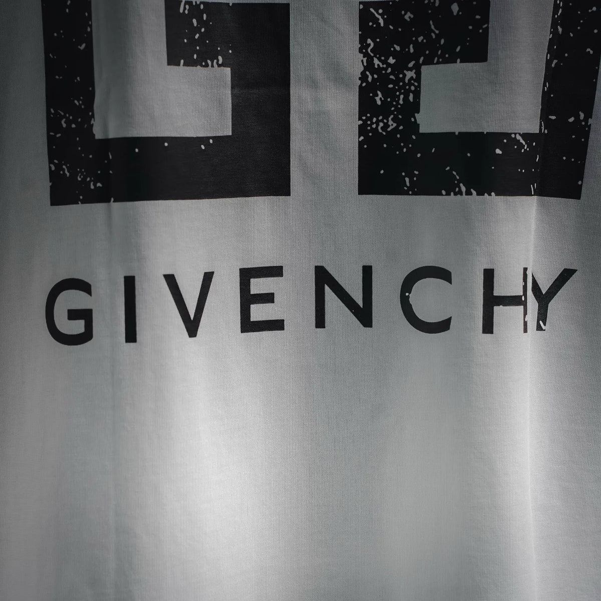 White T-shirt back with large GIVENCHY text beneath abstract cross blocks