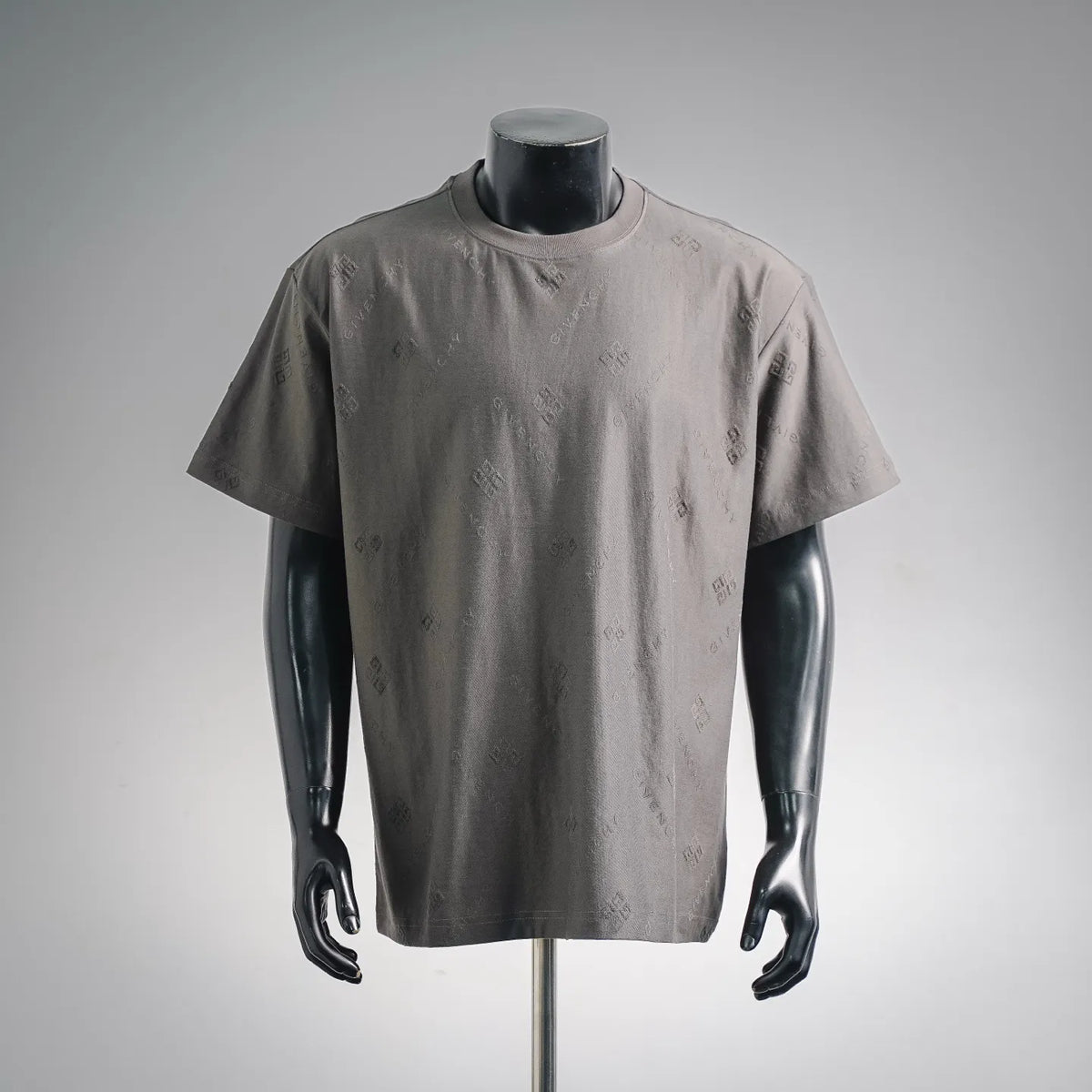 Gray short-sleeve crewneck T-shirt on a mannequin, with subtle allover logo print.