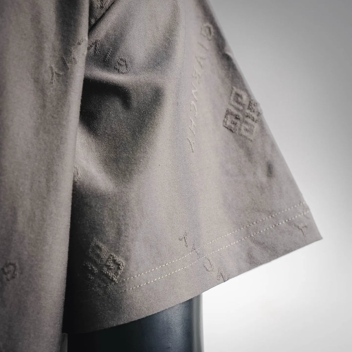 Gray short-sleeve T-shirt sleeve and side hem with dotted logo print.